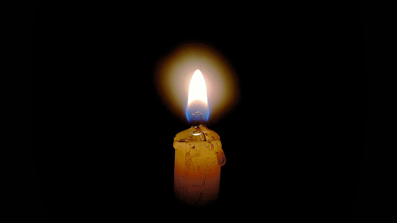 Vela encendida en una habitación a oscuras